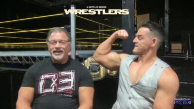 Al Snow and Mr PEC-Tacular Jessie Godderz showing his pecs to the audience.